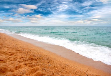 Deniz dalgaları ve kumlu plaj açık hava aktivitelerinin bir unsuru.