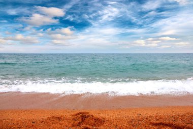 Deniz dalgaları ve kumlu plaj açık hava aktivitelerinin bir unsuru.