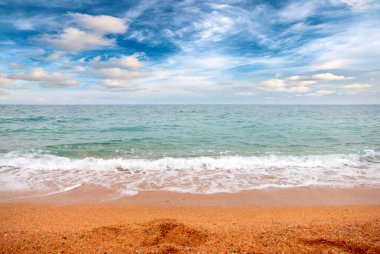 Deniz dalgaları ve kumlu plaj açık hava aktivitelerinin bir unsuru.