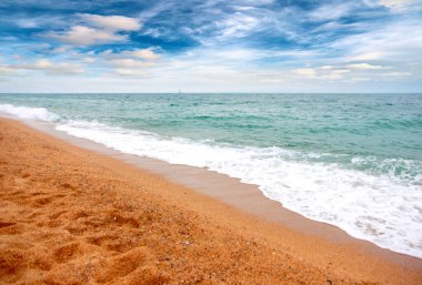 Deniz dalgaları ve kumlu plaj açık hava aktivitelerinin bir unsuru.