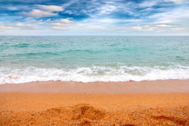 Deniz dalgaları ve kumlu plaj açık hava aktivitelerinin bir unsuru.