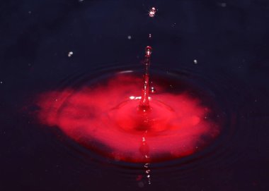 Kirli zehirli suyun yüzeyine kan kırmızı sıvı damlıyor.