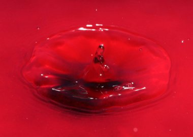 Zehirli su yüzeyine kırmızı sıvı damlası