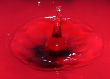 Zehirli su yüzeyine kırmızı sıvı damlası