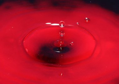 Zehirli su yüzeyine kırmızı sıvı damlası