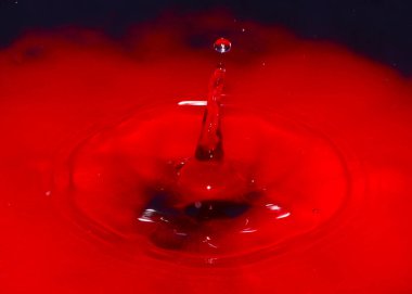 Zehirli su yüzeyine kırmızı sıvı damlası