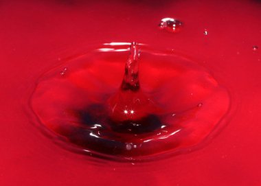 Zehirli su yüzeyine kırmızı sıvı damlası