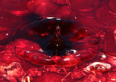 Sıvının altında elmaslar ve madeni paralar var. Şu anda bir damla su düşüyor.