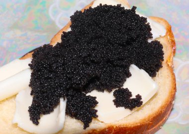 Tereyağlı beyaz buğday ekmekli sandviç ve siyah sevruga havyarı.