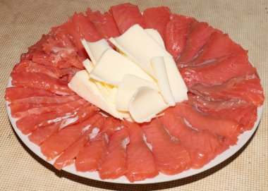 Tuzlu kırmızı balık dilimleri ve bir tabak tereyağı.