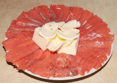 Tuzlu kırmızı balık dilimleri ve bir tabak tereyağı.