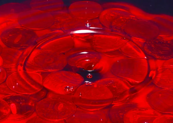 Gocce Liquido Rosso Una Pila Monete Metalliche Sotto Uno Strato — Foto Stock