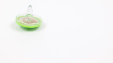 Beyaz bir yüzey üzerinde dönen bir çocuk oyuncağının dönüşümlü hareketi