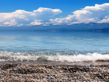 Akdeniz 'in güzel çakıl taşı plajı güneşli gökyüzünün altında