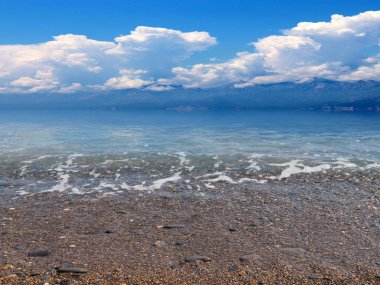 Akdeniz 'in güzel çakıl taşı plajı güneşli gökyüzünün altında