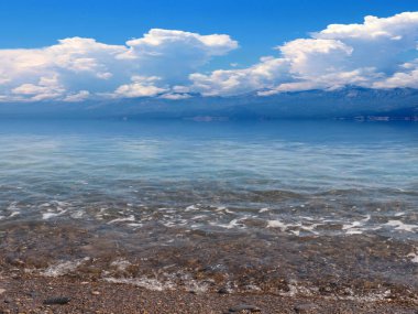 Akdeniz 'in güzel çakıl taşı plajı güneşli gökyüzünün altında