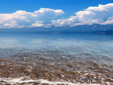 Akdeniz 'in güzel çakıl taşı plajı güneşli gökyüzünün altında