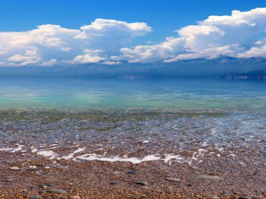 Akdeniz 'in güzel çakıl taşı plajı güneşli gökyüzünün altında