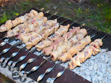 Açık ateşte şişte sulu et pişirmek.