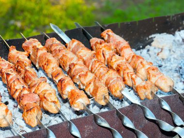 Izgaradaki şişte kızarmış et pişirme işlemi.