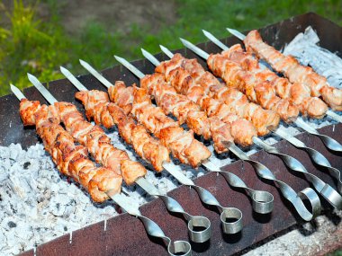 Izgaradaki şişte kızarmış et pişirme işlemi.