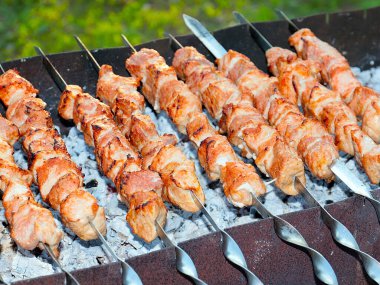 Izgaradaki şişte kızarmış et pişirme işlemi.