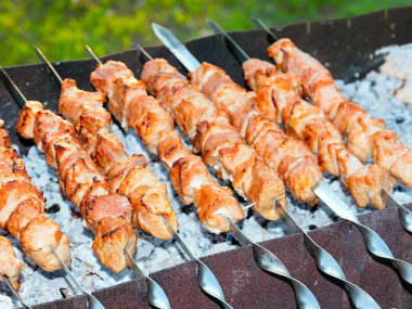 Izgaradaki şişte kızarmış et pişirme işlemi.