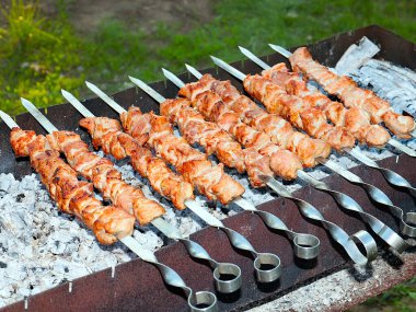 Izgaradaki şişte kızarmış et pişirme işlemi.