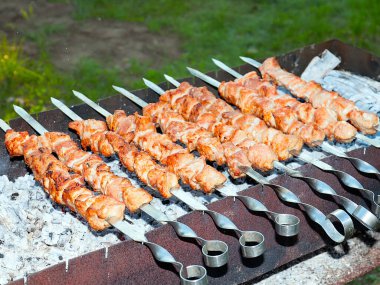 Izgaradaki şişte kızarmış et pişirme işlemi.