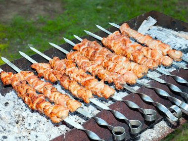 Izgaradaki şişte kızarmış et pişirme işlemi.