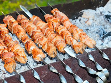 Izgaradaki şişte kızarmış et pişirme işlemi.