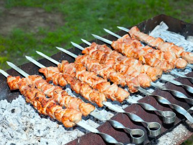 Izgaradaki şişte kızarmış et pişirme işlemi.