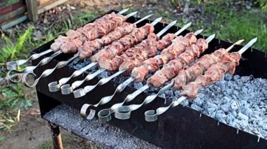 Izgarada kömür üstünde sulu etten şiş kebap pişirme işlemi