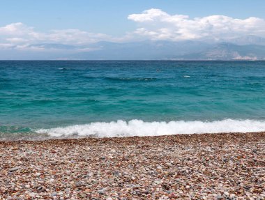 Güneşli gökyüzünün altında dinlenme yeri olarak çakıl taşı plajı