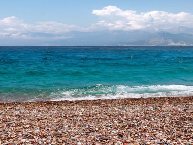 Güneşli gökyüzünün altında dinlenme yeri olarak çakıl taşı plajı