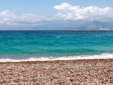 Güneşli gökyüzünün altında dinlenme yeri olarak çakıl taşı plajı