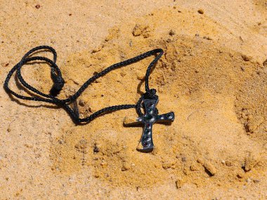 Dini semboller değerli taşlı mücevherlerle kumun üzerinde uzanır.