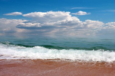 Güneşli gökyüzünün altında açık hava aktiviteleri için güzel kumlu deniz plajı.