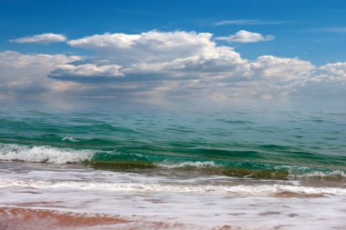 Güneşli gökyüzünün altında açık hava aktiviteleri için güzel kumlu deniz plajı.