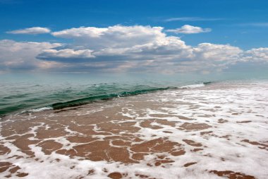 beautiful landscape with pebble beach and waves of the sea against the backdrop of a cloudy sky