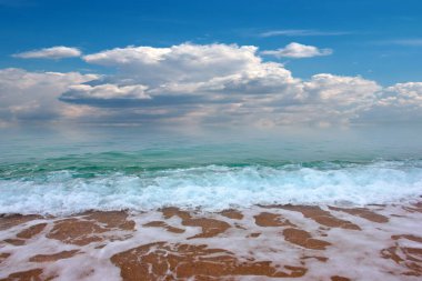 Güzel dalgalar ve deniz sahilleri Bulutlu yaz güneşinin altında