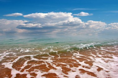 Güzel dalgalar ve deniz sahilleri Bulutlu yaz güneşinin altında