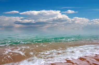 Güzel dalgalar ve deniz sahilleri Bulutlu yaz güneşinin altında