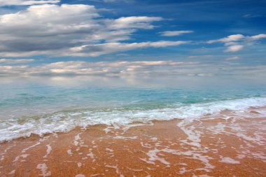 Güzel dalgalar ve deniz sahilleri Bulutlu yaz güneşinin altında