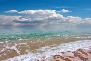 Güzel dalgalar ve deniz sahilleri Bulutlu yaz güneşinin altında