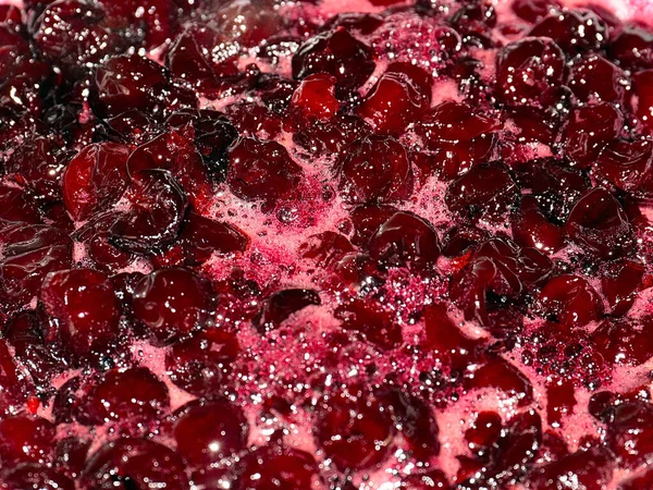 Ateş üstünde pişerken kiraz reçeli yüzeyinde köpük kaynıyor.