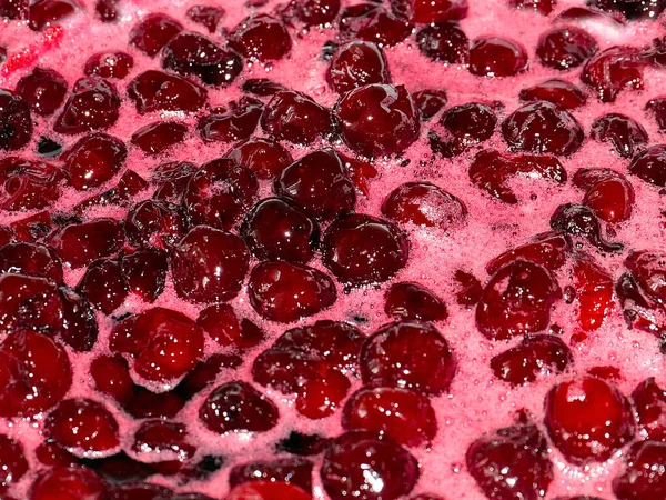 Ateş üstünde pişerken kiraz reçeli yüzeyinde köpük kaynıyor.