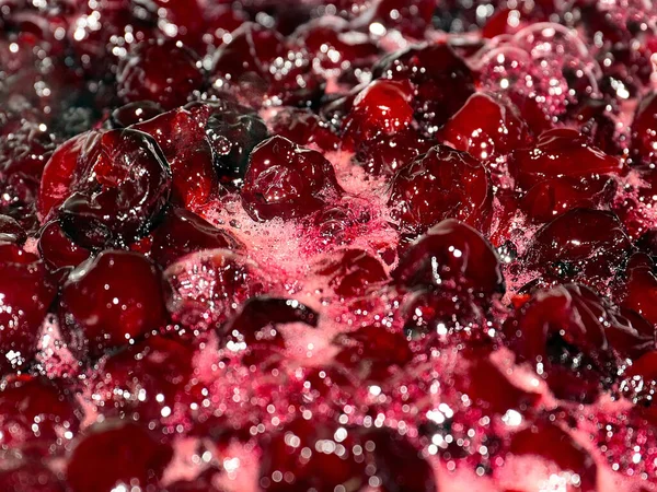 Ateş üstünde pişerken kiraz reçeli yüzeyinde köpük kaynıyor.