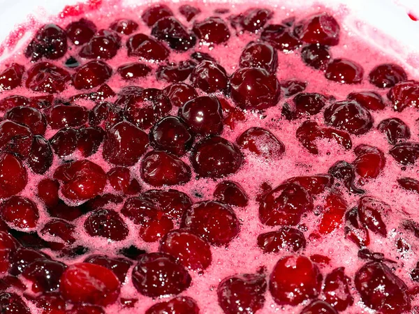 Ateş üstünde pişerken kiraz reçeli yüzeyinde köpük kaynıyor.