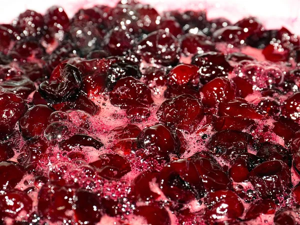 Ateş üstünde pişerken kiraz reçeli yüzeyinde köpük kaynıyor.